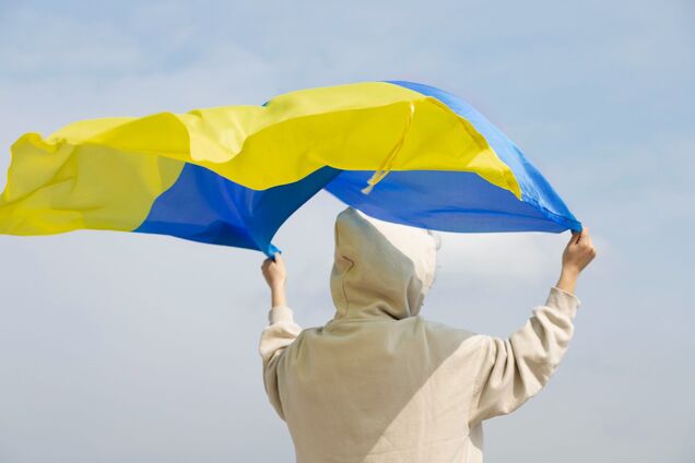 Ілюстрація - людина тримає прапор України