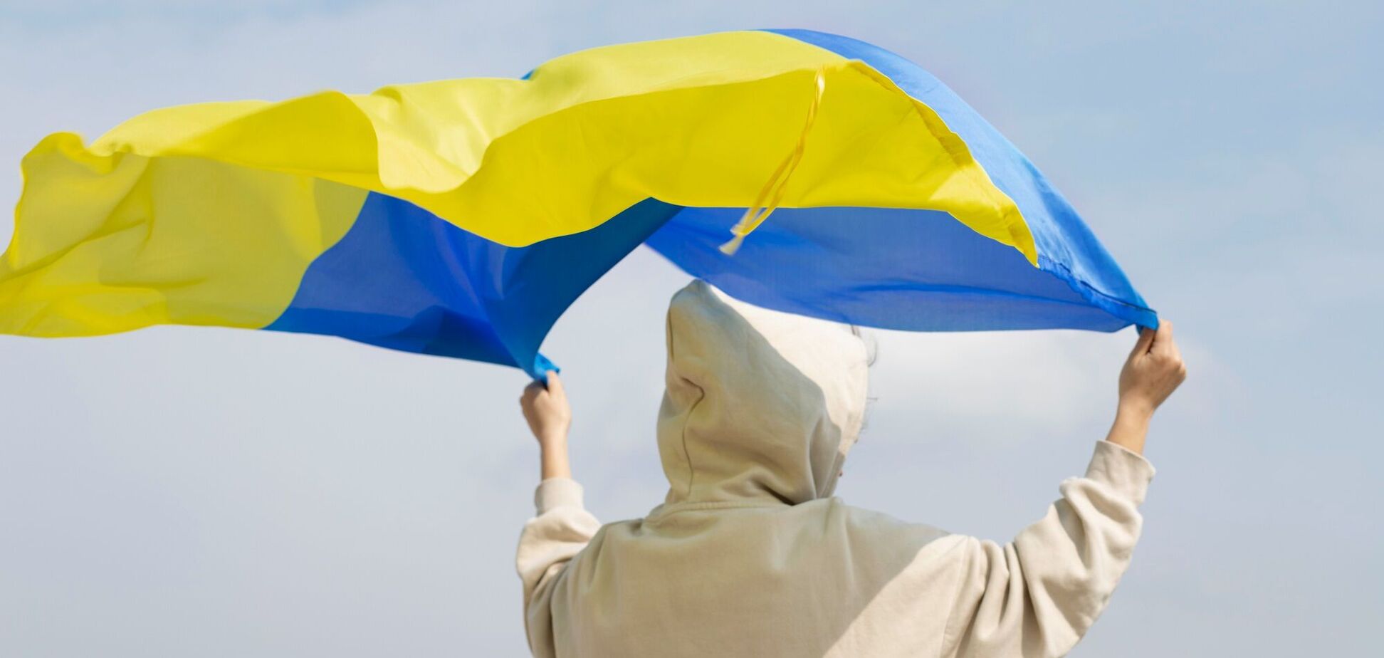 Иллюстрация — человек держит флаг Украины