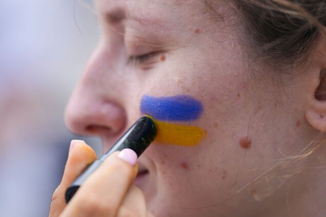 Ілюстрація - жінці наносять на обличчя кольори прапору України