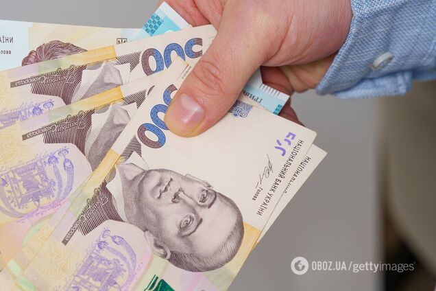 Гривні в руках. Ілюстрація
