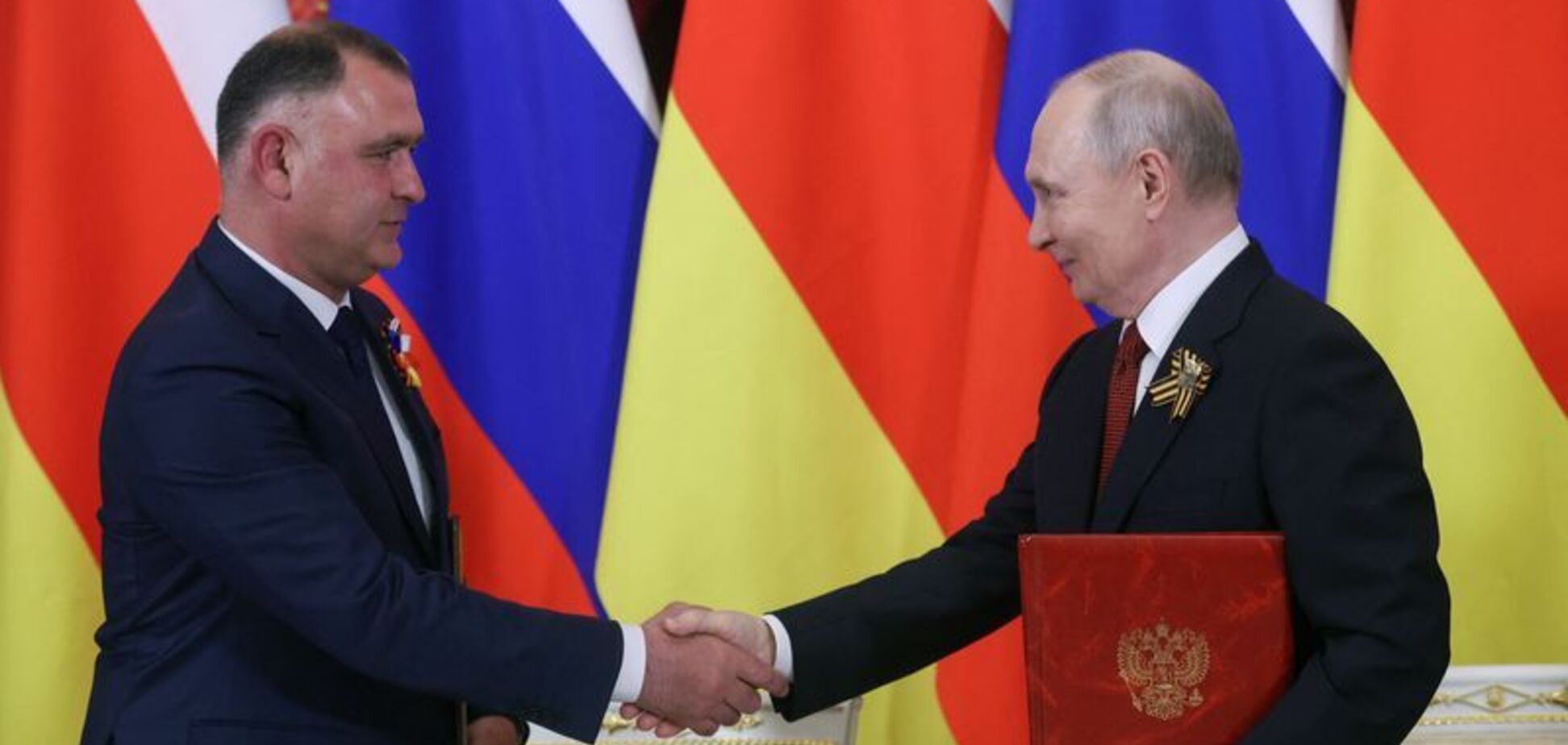 Президент России Владимир Путин (справа) и Алан Гаглоев, президент сепаратистского грузинского региона Южная Осетия, присутствуют на церемонии подписания документов после встречи в Кремле (Москва, Россия), 9 мая 2026 года