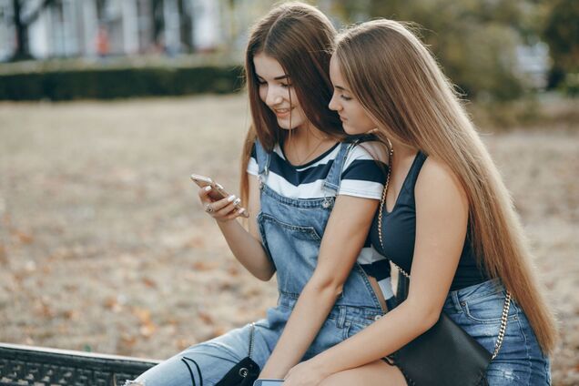 Ілюстрація - підлітки дивляться у смартфон